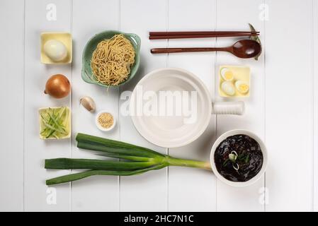 Nourriture Knolling asiatique Noodle, Flat Lay concept Ingrédients de Jajangmyeon ou Jjajangmyeon, nouilles coréennes avec sauce aux haricots noirs.Sur fond de bois blanc Banque D'Images