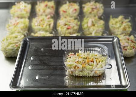 Livraison de la nourriture. Le chef prépare la nourriture dans le restaurant et la prépare dans des plats jetables.Place les boîtes à lunch jetables en plastique sur l'électronique Banque D'Images