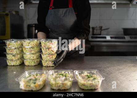 Les produits alimentaires jetables sont prêts à être livrés.Dans le restaurant, le chef prépare la nourriture et est emballé dans des boîtes à lunch jetables pour l'expédition. Piles Banque D'Images