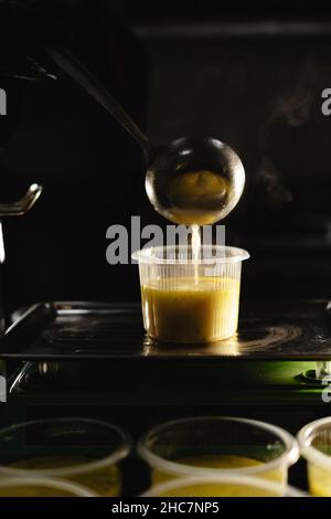 Livraison de nourriture au restaurant.Le chef prépare et prépare les aliments dans des plats jetables sur une balance pesant la portion requise.Gros plan d'un Banque D'Images