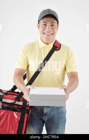 Messagerie joyeuse avec un grand sac isolé rouge donnant des boîtes de pizza chaude au client Banque D'Images