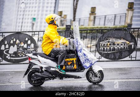 Guiyang, province chinoise de Guizhou.26th décembre 2021.Un livreur passe dans la neige à Guiyang, dans la province de Guizhou, au sud-ouest de la Chine, le 26 décembre 2021.Credit: Tao Liang/Xinhua/Alamy Live News Banque D'Images