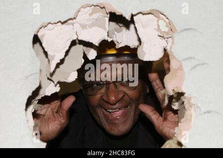 Photo du dossier datée du 21/05/06 de Desmond Tutu qui traverse un trou qu'il a frappé dans un mur à l'hôpital St. Luke pour le clergé, dans le centre de Londres.Desmond Tutu, activiste lauréat du prix Nobel de la paix pour la justice raciale et les droits des LGBT, est décédé à l'âge de 90 ans.Il avait été soigné à l'hôpital plusieurs fois depuis 2015, après avoir reçu un diagnostic de cancer de la prostate en 1997.Date de publication : dimanche 26 décembre 2021. Banque D'Images