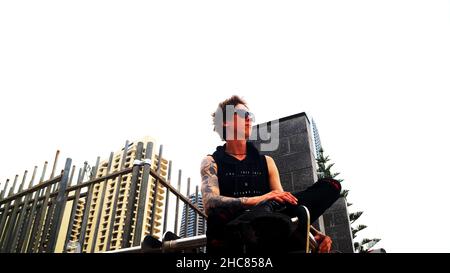 Prise de vue en angle d'un jeune homme adulte tatoué qui regarde à distance et envisage l'avenir Banque D'Images