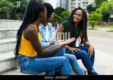 Groupe de jeunes adultes afro-américains, hommes et femmes, en plein air en ville en été Banque D'Images