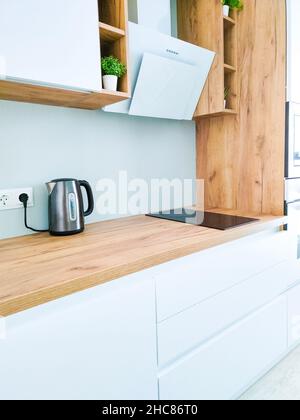 Cuisine blanche intérieure scandinave avec hotte sur comptoir en bois Banque D'Images