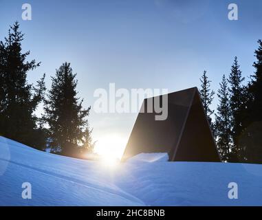 Magnifique paysage d'hiver de Camp maison à la montagne enneigée avec soleil lumineux à Almaty avec forêt d'épinettes contre ciel bleu nuageux au Kazakhstan Banque D'Images