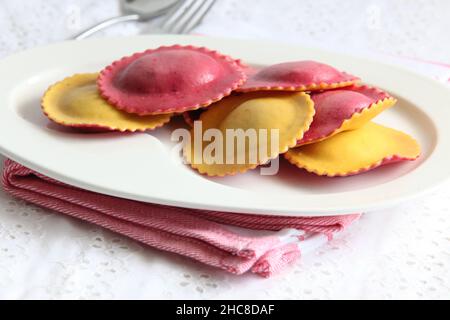 Une assiette de raviolis de couleur et aromatisés aux tomates fraîchement cuites (pâtes farcies) Banque D'Images