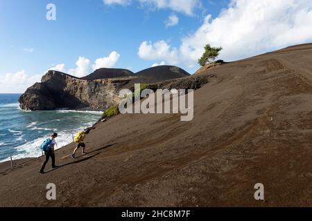 Mère et fils marchant dans le désert de cendres au volcan Capelinhos, phare de Ponta dos Capelinhos sur la côte ouest sur l'île de Faial, Açores, Portugal Banque D'Images