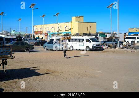 Un homme portant s'est élevé sur la tête dans une rue de Nouakchott Banque D'Images