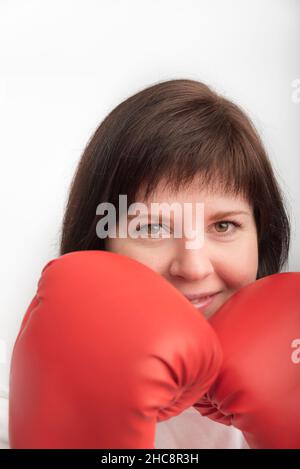 Portrait en gros plan de la jeune femme aux cheveux foncés en gants de lutte rouges.Boxeur femme.Cadre vertical. Banque D'Images