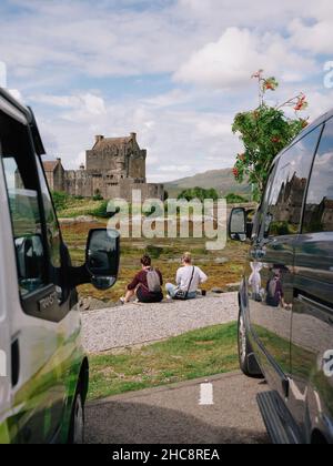 Visite de touristes d'été se détendre pendant une journée d'été au château d'Eilean Donan à Loch Duich, Kyle de Lochalsh, West Highlands Scotland UK Banque D'Images