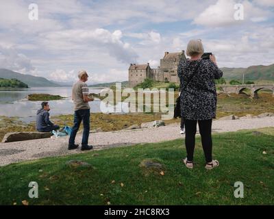 Visite de touristes d'été prenant des photos au château d'Eilean Donan à Loch Duich, Kyle de Lochalsh, West Highlands Scotland UK Banque D'Images