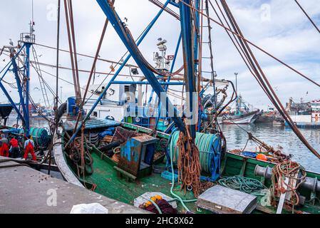 Bateaux de pêche en bois ancrés à côté de la jetée de la marina, dans un ciel nuageux Banque D'Images