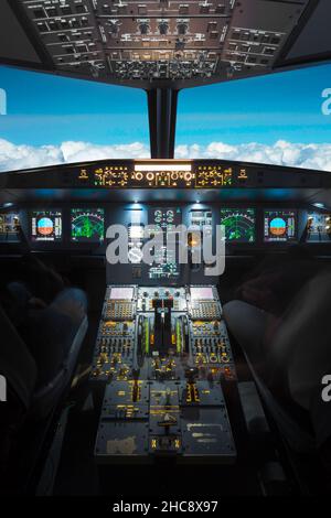 à l'intérieur d'un grand cockpit d'avion volant, volant au-dessus des nuages Banque D'Images