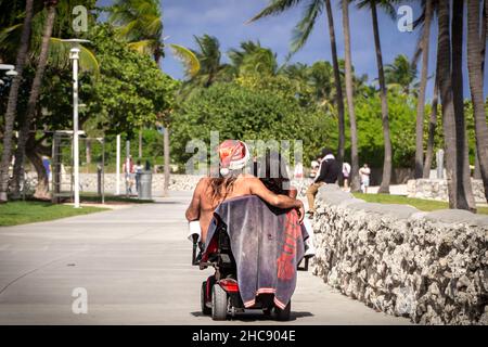 Santa et son petit assistant sur fauteuil roulant électrique Banque D'Images