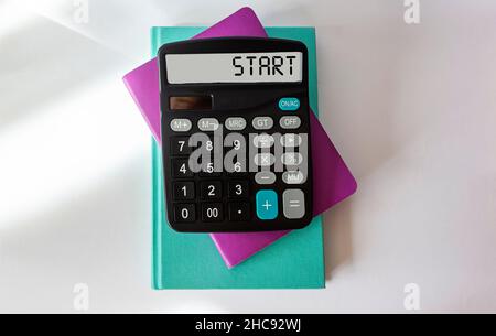 Texte de démarrage sur l'écran de la calculatrice avec bloc-notes sur fond blanc Banque D'Images