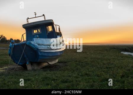 Vieux bateau de pêche au coucher du soleil dans le Gower South Wales Banque D'Images