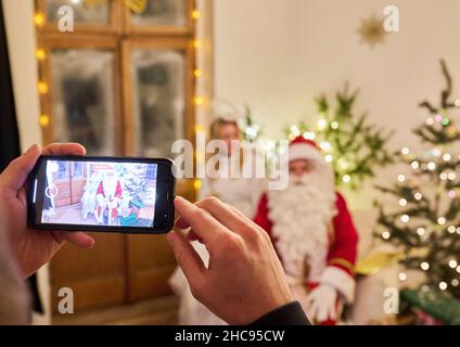 Berlin, Allemagne.08th décembre 2021.Un Père Noël, avec son ange, enregistre un message personnalisé pour une famille.En raison de la pandémie, les dons personnalisés sont limités.Le message du Père Noël devient un message vidéo.Credit: Annette Riedl/dpa/Alay Live News Banque D'Images