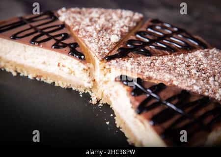 Gros plan sur une tranche de cheesecake au cacao et à la sauce au chocolat. Banque D'Images