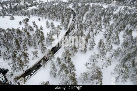 Paysage aérien de drone de route traversant le paysage enneigé de forêt de montagne à Winte Banque D'Images