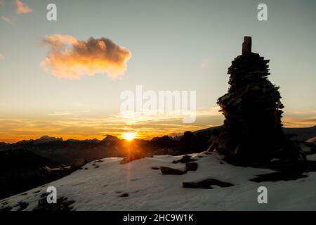 Cairn de pierre sur une crête de montagne enneigée près de Rifugio Quintino Sella al Felik Banque D'Images