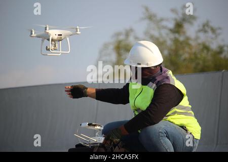 un opérateur de drone volant son drone pour enregistrer l'atmosphère au travail Banque D'Images