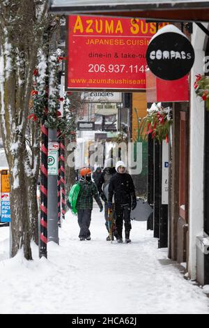 Seattle, Washington, États-Unis.26th décembre 2021.Un groupe de jeunes hommes portent des traîneaux à West Seattle Junction alors qu'une tempête d'hiver frappe Seattle le dimanche 26 décembre 2021.Crédit : Paul Christian Gordon/Alay Live News Banque D'Images