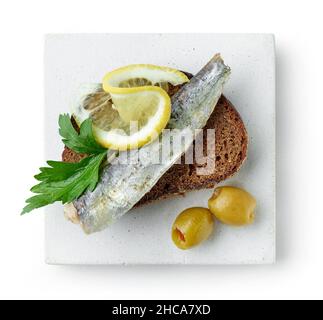 plaque de sandwich avec sardine en conserve isolée sur fond blanc, vue de dessus Banque D'Images