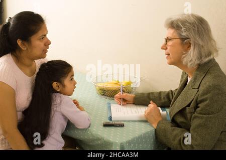 Chercheur interviewant une fille de 3 ans et sa mère à la maison famille est Mexicain chercheur américain est blanc Banque D'Images