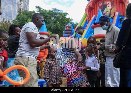 Nairobi, Kenya.25th décembre 2021.Un fournisseur vendant des ombres aux enfants le jour de Noël.Pendant de nombreuses années, les Kenyans vivant à Nairobi et ses environs passent le jour de Noël dans les parcs d'Uhuru et Central.Toutefois, ce n'est pas le cas cette année, car les deux parcs restent fermés pour rénovations.Cela ne les a pas empêcher de profiter de la journée dans de petits espaces disponibles.Crédit : SOPA Images Limited/Alamy Live News Banque D'Images