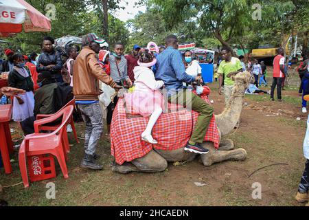 Nairobi, Kenya.25th décembre 2021.Un père et une fille qui vont faire une balade à dos de chameau, le jour de Noël.Pendant de nombreuses années, les Kenyans vivant à Nairobi et ses environs passent le jour de Noël dans les parcs d'Uhuru et Central.Toutefois, ce n'est pas le cas cette année, car les deux parcs restent fermés pour rénovations.Cela ne les a pas empêcher de profiter de la journée dans de petits espaces disponibles.(Photo de Boniface Muthoni/SOPA Images/Sipa USA) Credit: SIPA USA/Alay Live News Banque D'Images