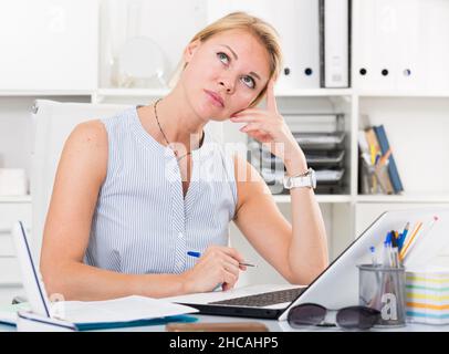 portrait d'une femme travaillant avec des documents et un ordinateur portable et ayant des problèmes au bureau de l'entreprise Banque D'Images