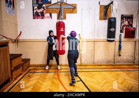 Berlin, Allemagne.16th décembre 2021.L'entraîneur de boxe Doha Taha Beydoun s'entraîne avec l'un de ses boxeurs.Elle n'a que 20 ans.Marié.Quatre mois de grossesse.Musulman et un entraîneur de boxe.Ses parents ont émigré du Liban vers l'Allemagne quand elle était bébé.Doha Taha Beydoun semble 'trange' à certains, dit-elle, parce que sa nationalité, sa religion et son sport ne correspondent pas.D'autres la voient comme un modèle, comme elle le dit elle-même."Je lutte contre tous les préjugés", dit la jeune femme en toute confiance.Credit: Fabian Sommer/dpa/Alay Live News Banque D'Images