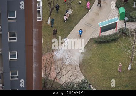XI'AN, CHINE - 27 DÉCEMBRE 2021 - photo aérienne prise le 27 décembre 2021 montre un travailleur effectuant une désinfection complète dans une communauté fermée à Xi ' Banque D'Images