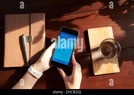 Mains d'une femme utilisant une application mobile bancaire pour payer des factures Banque D'Images