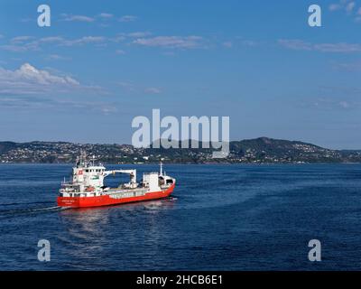 Le Kristian with, un navire de fret général à Bergen Fjord se dirigeant vers la mer du Nord dans une eau calme avec des courants de surface visibles. Banque D'Images