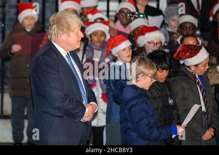 Le Premier ministre Boris Johnson écoute un chœur d'enfants lors d'un événement de Noël devant Downing Street, Londres Banque D'Images