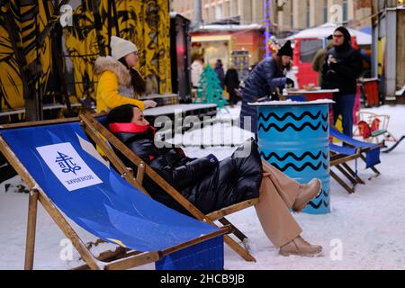 Minsk, Bélarus, le 25 décembre 2021 : une femme est assise sur un fauteuil de pont au salon du nouvel an.Les gens marchent et s'amusent. Banque D'Images
