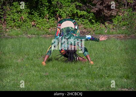 Une femme agile dans ses années 50 à un cours de yoga méditatif dans un parc à Flushing, Queens, New York City. Banque D'Images