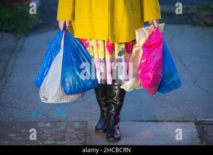 Dossier non daté photo d'une femme porte des achats dans des sacs de transport en plastique à Londres.Les acheteurs rejettent les sacs en plastique à usage unique pour sauver des centimes plutôt que la planète, une étude de « big data » menée auprès de plus de 10 000 000 consommateurs a révélé.Les recherches menées par le centre d'excellence N/LAB analytique de la Nottingham University Business School suggèrent que la baisse massive de l'utilisation des sacs en plastique au Royaume-Uni pourrait avoir peu à voir avec les acheteurs qui s'inquiètent de l'environnement.Date de publication : lundi 27 décembre 2021. Banque D'Images