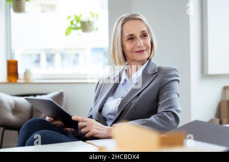 Femme d'affaires attentionnés avec les mains sur le menton au bureau Banque D'Images