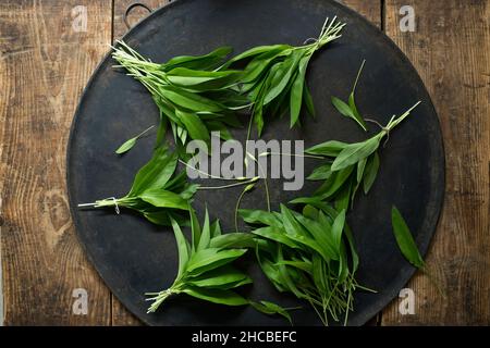 Photo de studio de faisceaux de ramson frais sur une feuille ronde Banque D'Images