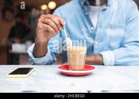 Homme remuant café au café Banque D'Images