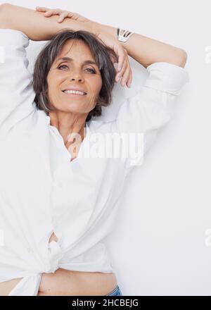 Femme mûre riant sur fond blanc Banque D'Images