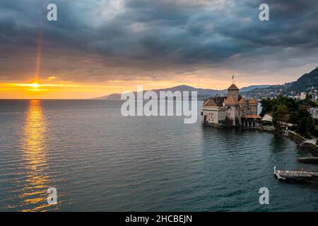 Suisse, canton de Vaud, Veytaux, vue aérienne du lac Léman au coucher du soleil nuageux avec château de Chillon en arrière-plan Banque D'Images