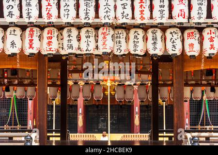 Vue à travers la scène ouverte de la salle Buden avec rangée de lanternes en papier blanc, chochin, pendante, à la salle principale du sanctuaire de Yaasaka à Kyoto. Banque D'Images