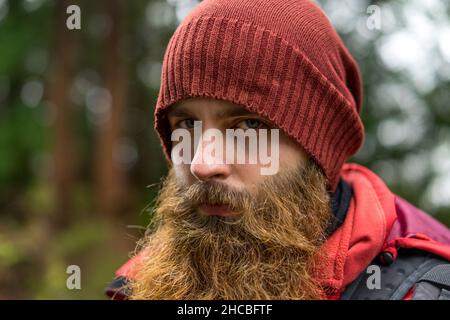 Jeune homme taille basse avec barbe brune portant un chapeau en tricot Banque D'Images