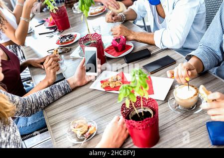 Vue de dessus des amis qui boivent du cappuccino au restaurant du café-restaurant - les gens qui s'amusent ensemble à manger et à utiliser un smartphone mobile Banque D'Images