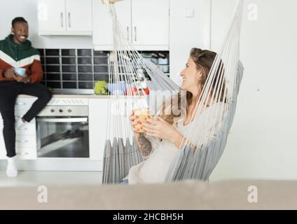 Femme enceinte avec homme dans la cuisine date de passage sur le calendrier à la maison Banque D'Images
